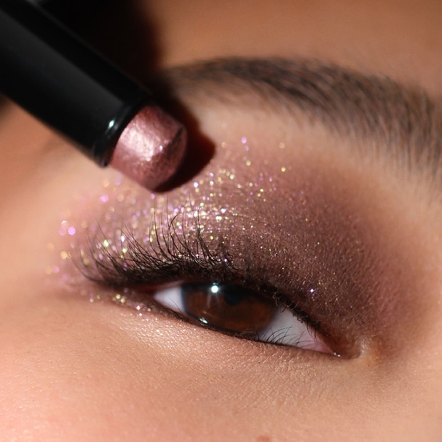 Close up of model eye showcasing defined brows and a natural, shimmery eye look